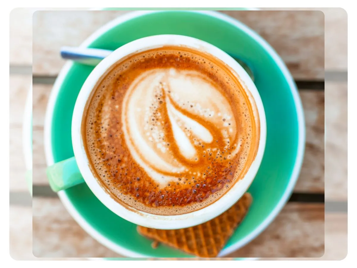 Uma xícara de expresso com uma rica camada de crema marron/dourada no topo em forma de coração.