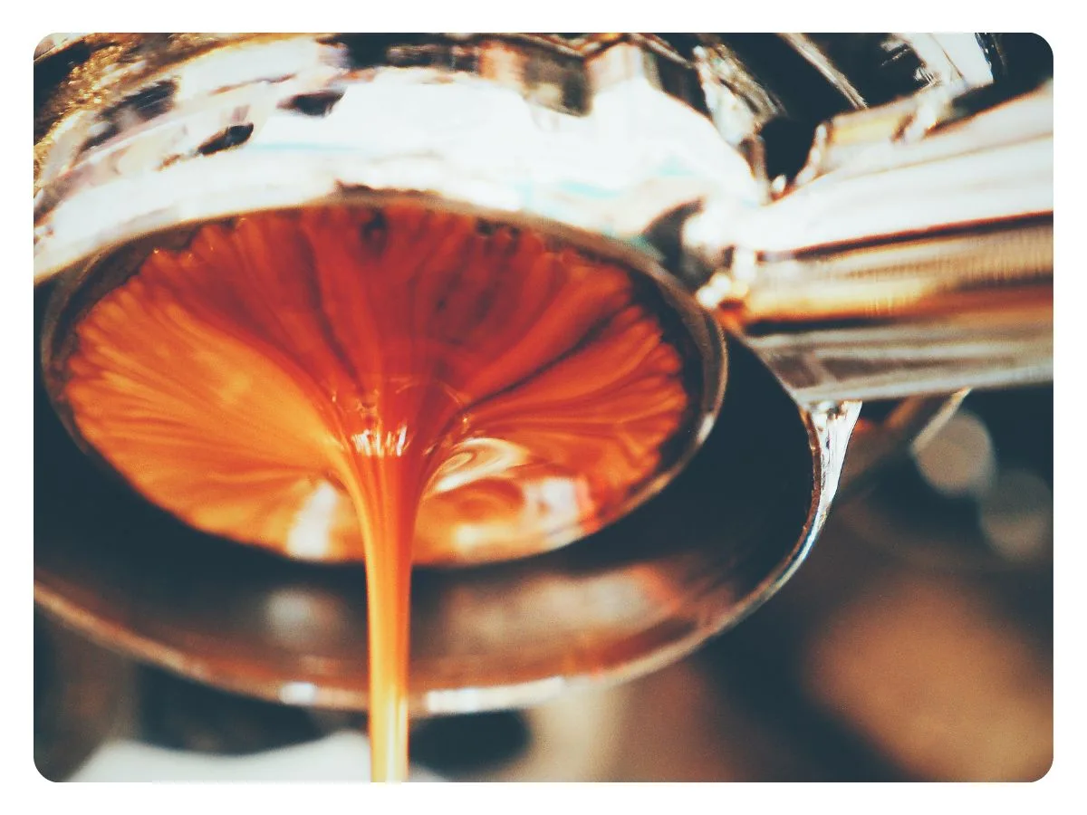 Close de uma linda crema pingando de uma máquina expresso.